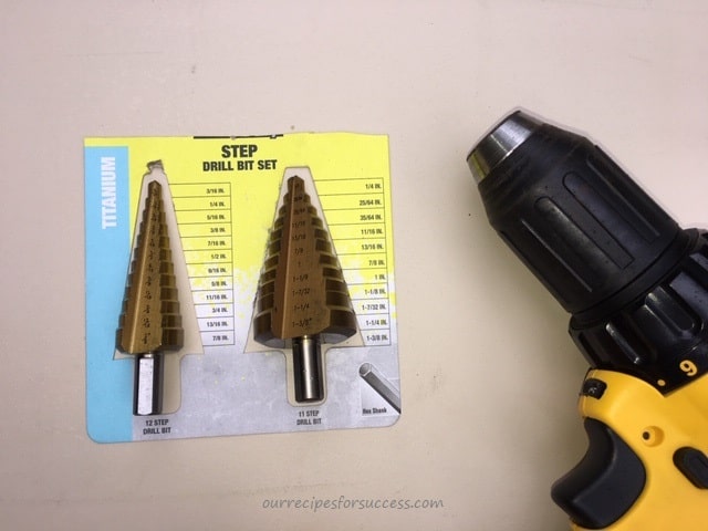 two step drill bits beside a drill