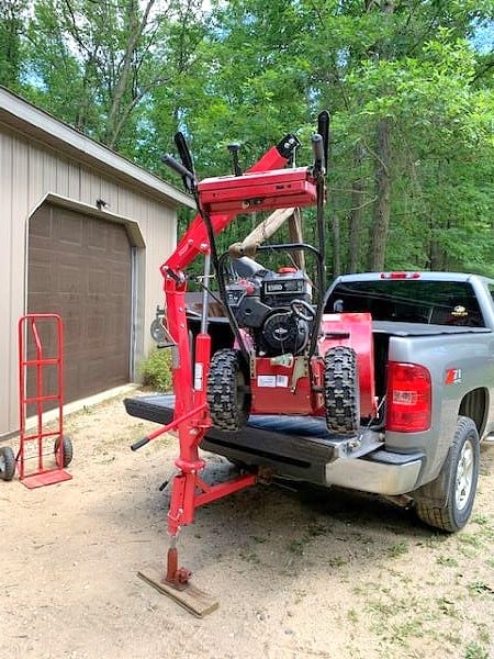 500 pound truck crane lifting a snowblower into the back of a truck